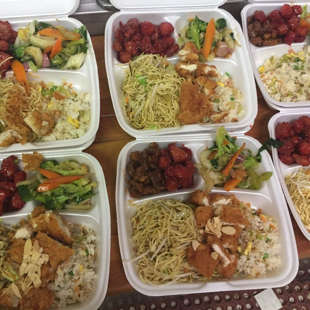 Take-out containers of stir fry, chow mein and sweet and sour dishes