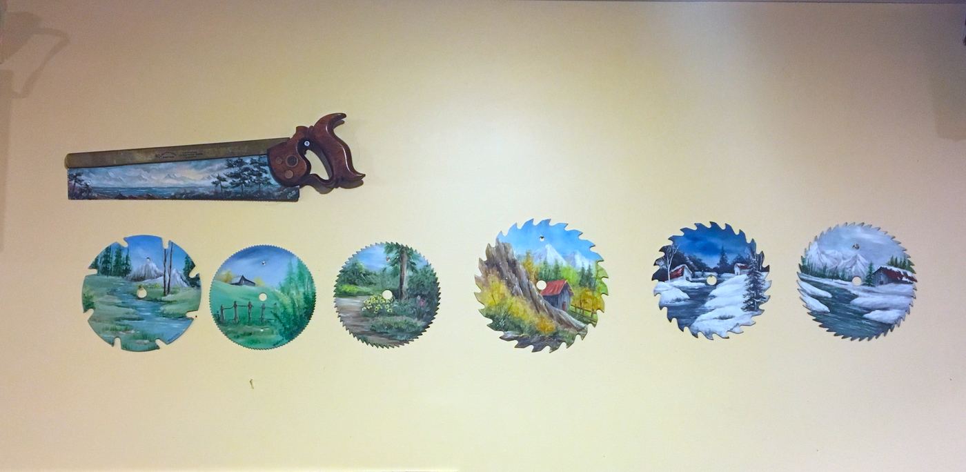 Hand-painted saw blades hung on a wall